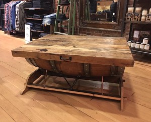 This coffee table is made from half of a wine barrel with a barn wood top.